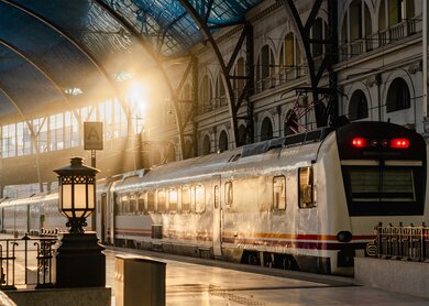 Das Innere des Bahnhofs France in Barcelona bei Sonnenaufgang mit Zügen | © Gettyimages.com/beingbonny
