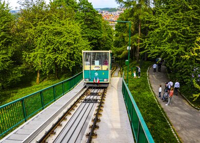 Die Petrin-Standseilbahn in der tschechichen Hauptstadt Prag, rechts laufen Passanten auf dem Petrin-Hügel im Mala-Strana-Viertel. | © Gettyimages.com/sphraner