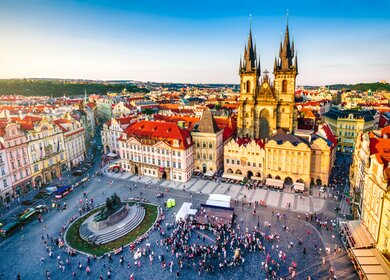 Luftaufnahme des Altstädter Rings in Prag bei Sonnenuntergang, auf dem Platz sind Menschen versammelt. | © Gettyimages.com/Eloi_Omella