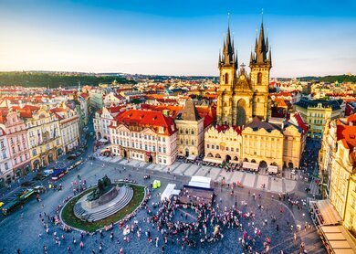 Luftaufnahme des Altstädter Rings in Prag bei Sonnenuntergang, auf dem Platz sind Menschen versammelt. | © Gettyimages.com/Eloi_Omella