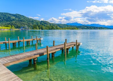 Holzsteg zum Festmachen von Booten auf See Woerthersee an schoenen Sommertag, Oesterreich | © Gettyimages.com/pkazmierczak