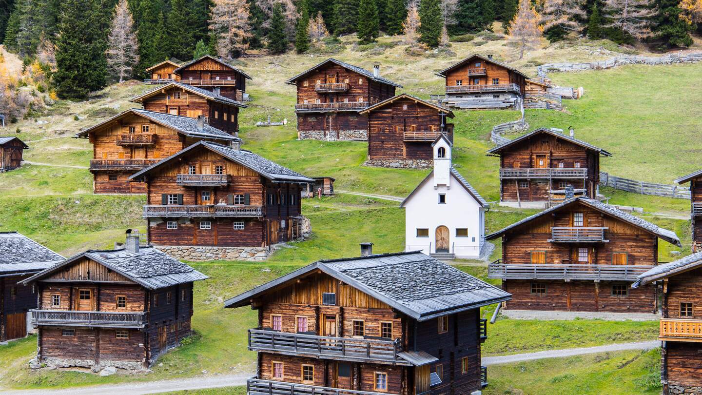 Idyllische Gruppe historischer Holzbauernhaeuser auf einer Osttiroler Alm in Oesterreich im Herbst | © Gettyimages.com/Photofex