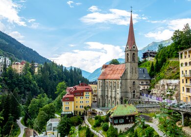 Panorama von Bad Gastein, dem Wolkenkratzerdorf im Salzburger Land an einem Sommertag mit der Kirche | © Gettyimages.com/Martin Schein