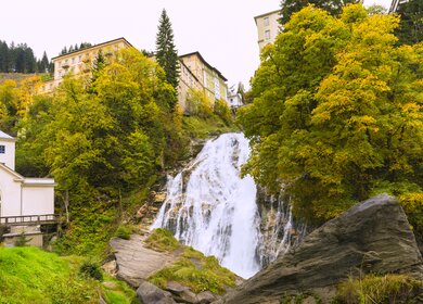 zwischen den hochgebauten Haeusern im schoenen Gastein stuerzt der Wasserfall runter  | © gettyimages.com/helovi