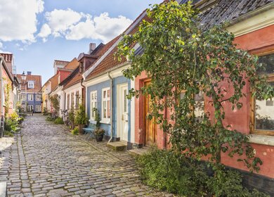 Eine idyllische Kopfsteinpflasterstrasse mit bunten Haeusern in der Altstadt von Aalborg | © Gettyimages.com/eyewave
