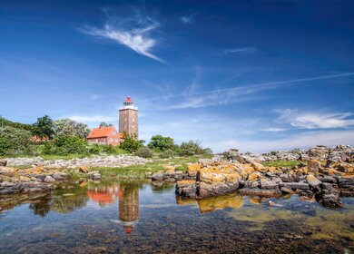 Leuchtturm von  Bornholm spigelt sich im Wasser des Meeres | © Gettyimages.com/cmfotoworks