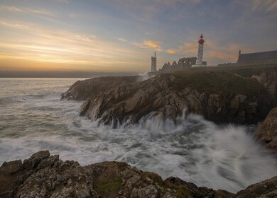Leuchtturm Pointe de Saint-Mathieu, Sonnenuntergang grosse Wellen, Bretagne (Bretagne), Frankreich | © Gettyimages.com/nikpal