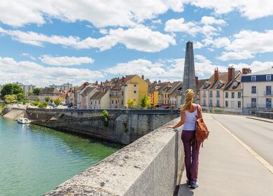 Frau steht auf der Brücke über die Saone mit Blick auf die Häuser der Stadt Chalon sur Saone im Burgund in Frankreich | © gettyimages.com/margouillatphotos