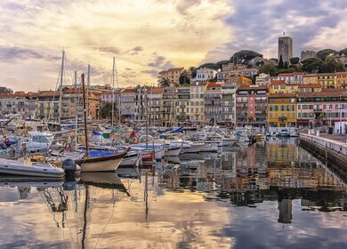 Hafen von Cannes mit bunten Haeusern und Schiffen bei Sonnenuntergang | © Gettyimages.com/StockByM