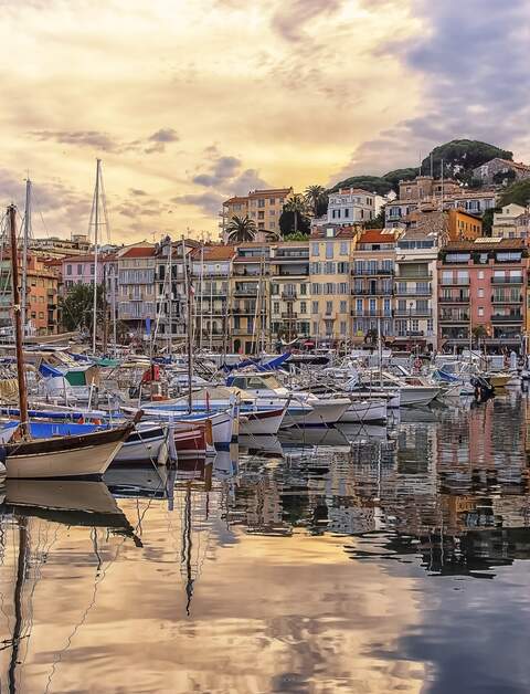 Hafen von Cannes mit bunten Haeusern und Schiffen bei Sonnenuntergang | © Gettyimages.com/StockByM