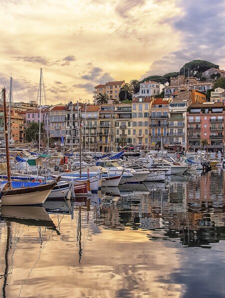Hafen von Cannes mit bunten Haeusern und Schiffen bei Sonnenuntergang | © Gettyimages.com/StockByM