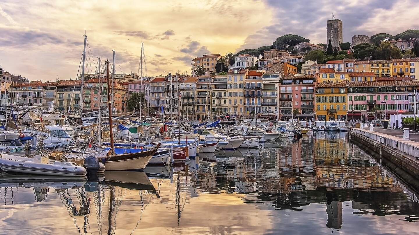 Hafen von Cannes mit bunten Haeusern und Schiffen bei Sonnenuntergang | © Gettyimages.com/StockByM