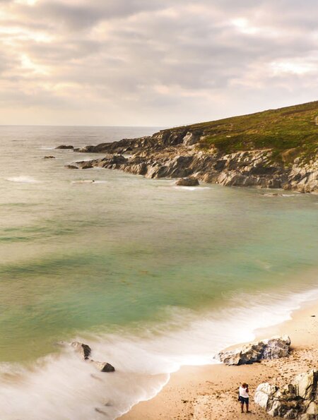 Panoramaansicht einer Küstenszene in Cornwall, England, mit einem Sandstrand, zerklüfteten Klippen und einer grasbewachsenen Landzunge | ©  aliciafabregas / 2016 Thinkstock.