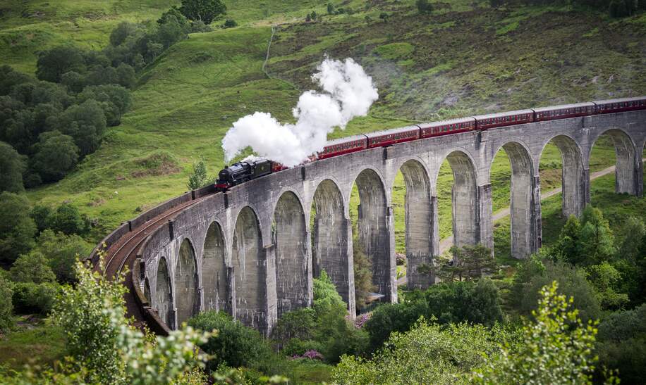 Dampfzug faehrt ueber das Glenfinnan-Viadukt in Schottland | © Gettyimages.com/wanderluster