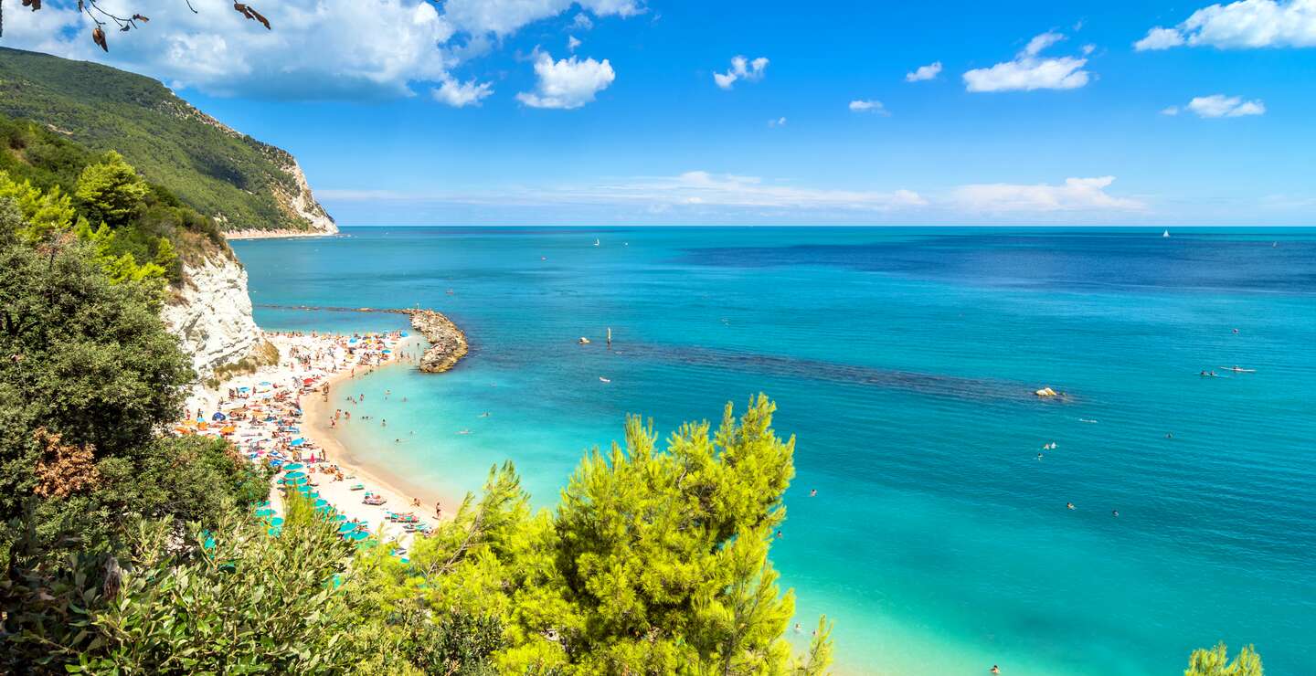 Tagesansicht des beruehmten Strandes voller Touristen in Sirolo, Italien | © Gettyimages.com/eddygaleotti