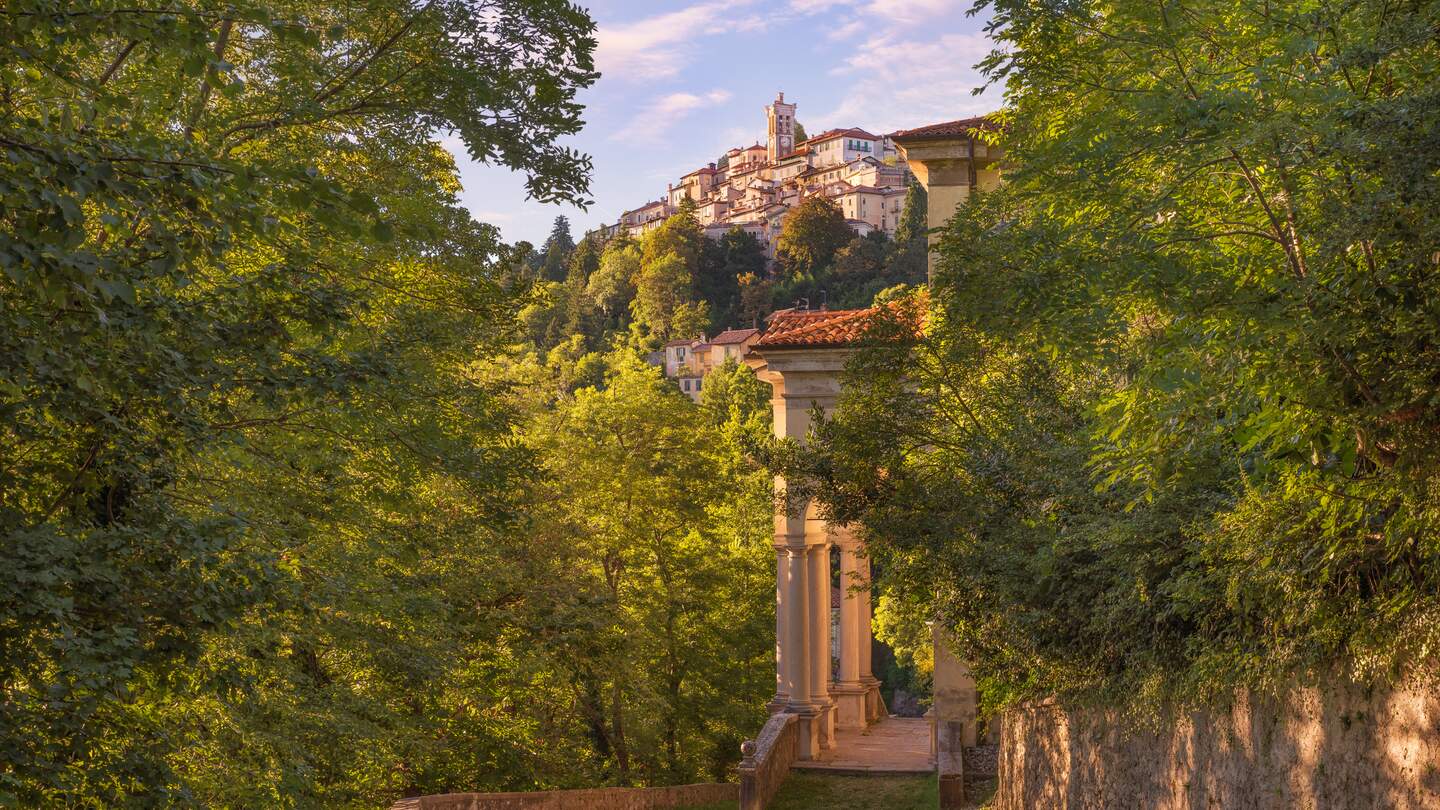 Der Sacro Monte von Varese oder Santa Maria del Monte befindet sich im Regionalpark Campo dei Fiori und ist einer der neun Sacri Monti (heilige Berge) in den italienischen Regionen Lombardei und Piemont, die 2003 in die UNESCO-Liste des Weltkulturerbes aufgenommen wurden. Es hat eine Hoehe von 807 Metern ueber dem Meeresspiegel. Das alte Dorf mit seinen 14 Kapellen, die sich entlang eines Kiesweges von etwa 2 km schlaengeln, ist wahrscheinlich die faszinierendste marianische Route der Welt. Sommerlandschaft bei Sonnenuntergang | © Gettyimages.com/alemasche72