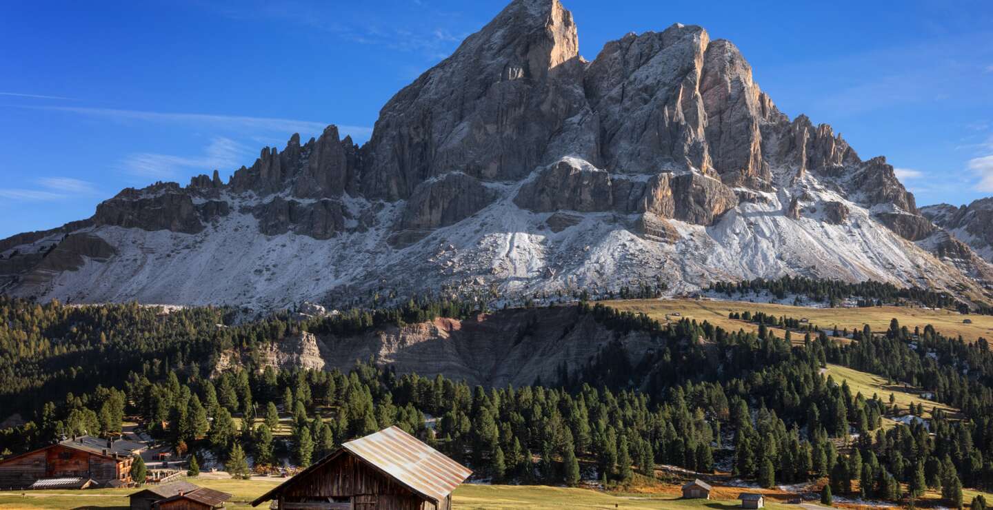 Berpanorama mit Schutzhuetten bei Sonnenschein, der Berg Peitlerkofel ist im Hintergrund zu sehen | © Gettyimages.com/Radu79