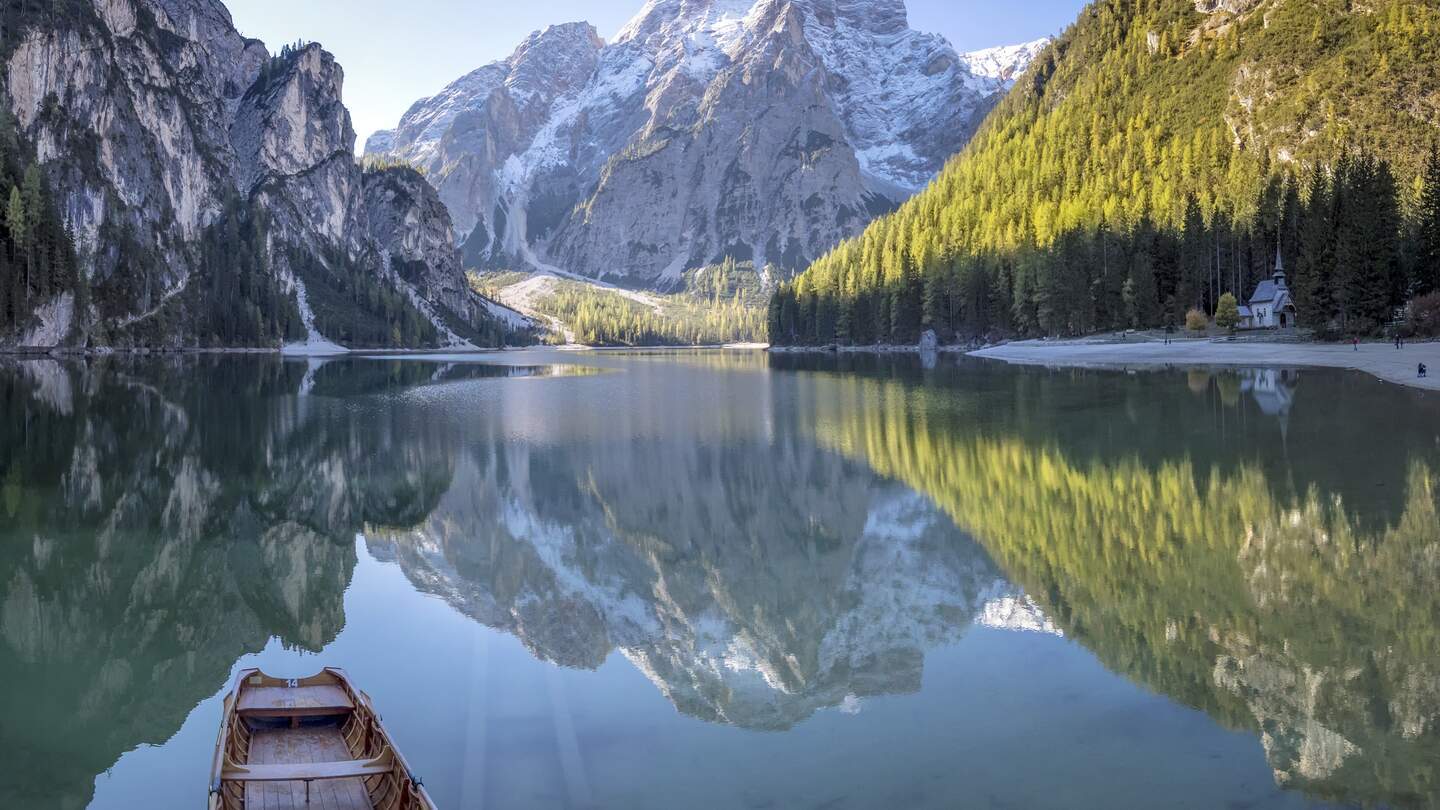 Pragser Wildsee mit kleinem Holzboot und Spiegelung der Berge im Sonnenschein | © Gettyimages.com/DieterMeyrl