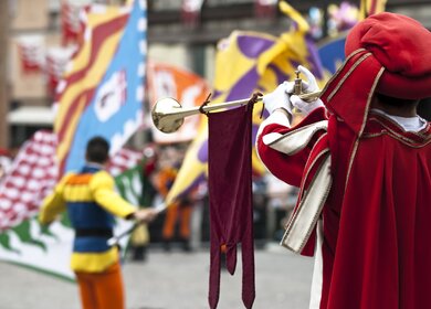 Traditionelles Pferderennen in der Innenstadt von Siena, die Flaggen symbolisieren die Stadtteile, die gegeneinander antreten | © Gettyimages.com/Flory