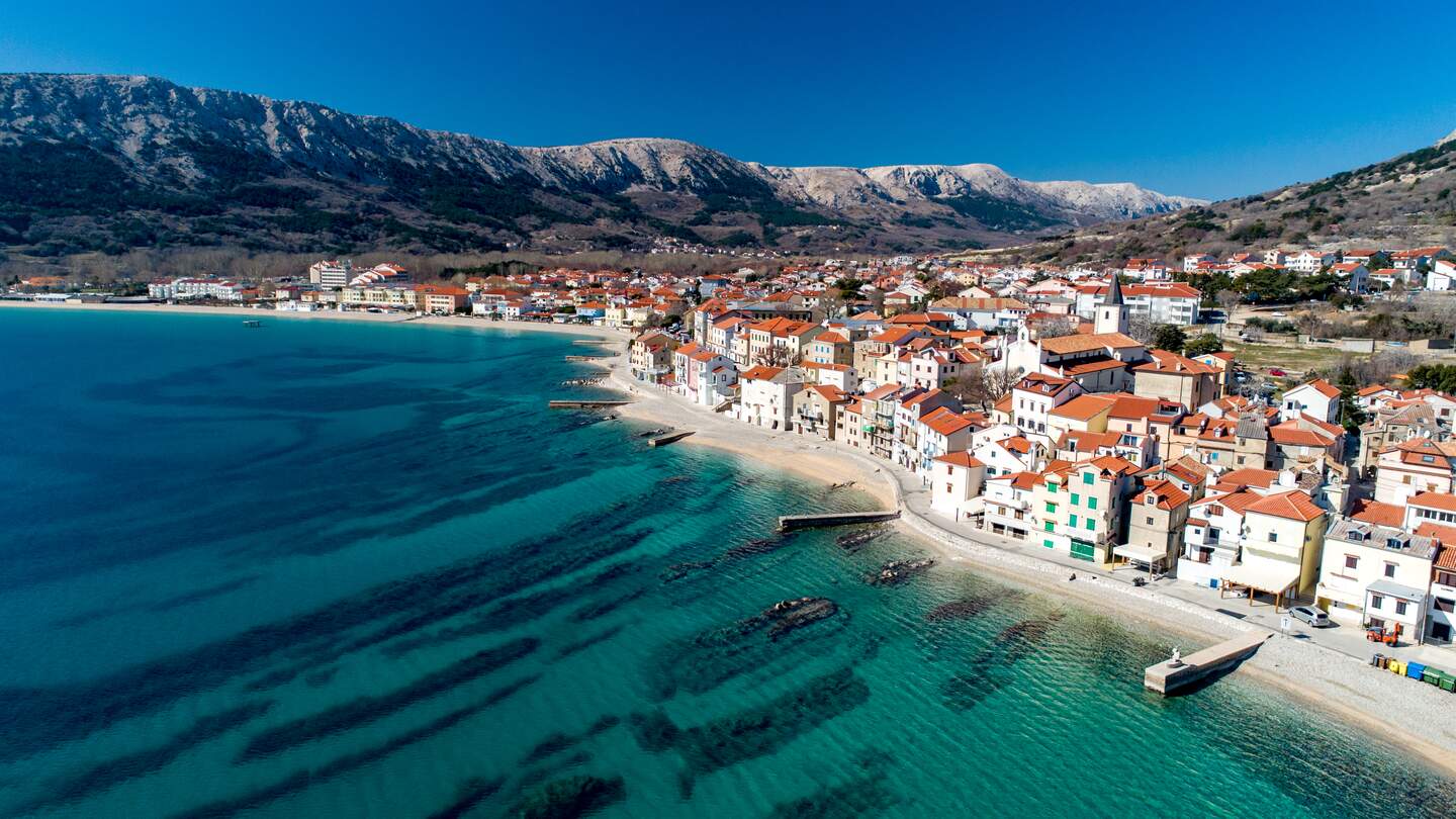 Luftaufnahme der Küstenstadt Baska auf der Insel Krk bei blauem Himmel | © Gettyimages.com/CasarsaGuru