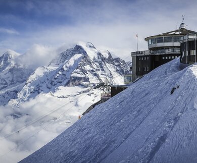 Die Bergstation auf dem schneebedeckten Gipfel in der Schweiz  | ©  Gettyimages.com/fotoVoyager
