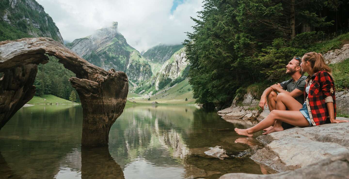 Paerchen sitzt am Rand des Seealpsees im Kanton Appenzell | © Gettyimage.com/Mystockimages