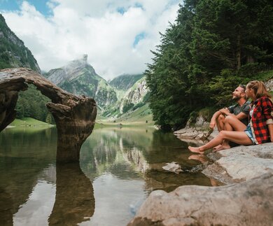 Paerchen sitzt am Rand des Seealpsees im Kanton Appenzell | © Gettyimage.com/Mystockimages