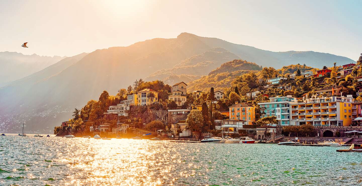 Sonnenuntergang am Abend in Ascona Luxus touristischen Resort Promenade am Lago Maggiore im Kanton Tessin in der Schweiz im Sommer. Menschen im Freien Straße reisen. Romantische Schweizer typische teure Stadt. | © Gettyimages.com/romanbabakin