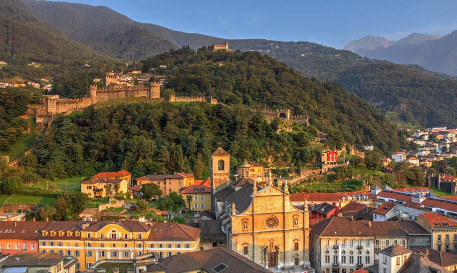 Bellinzona, mit zwei der Stadtschloesser: Montebello und Sasso Corbaro, sowie der Stiftskirche St. Peter und Stephan in der Altstadt | © gettyimages.com/BogdanLazar