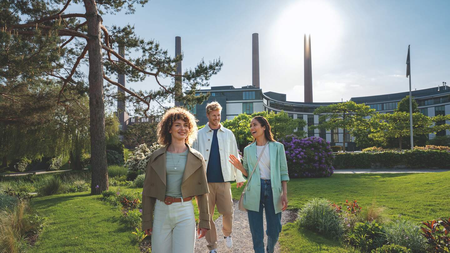Besucher der Autostadt Wolfsburg laufen durch die Parklandschaft | © Magnus Winter