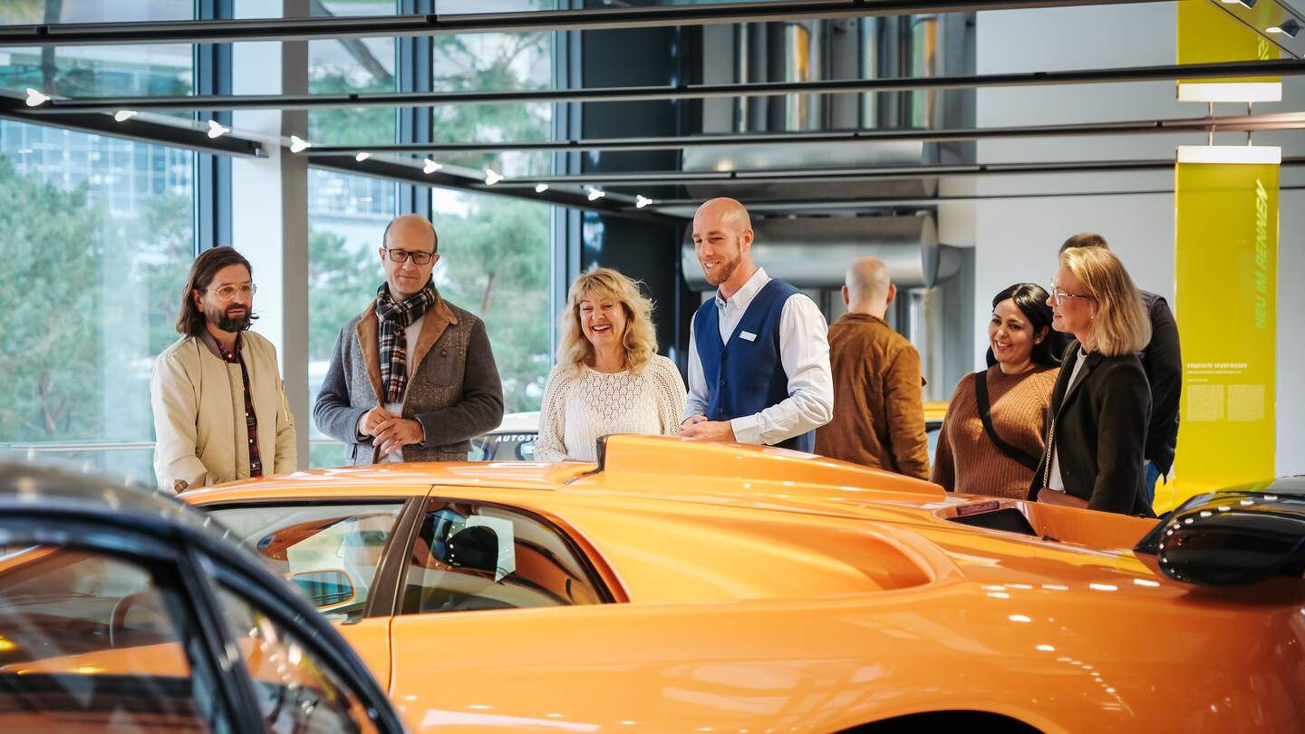 Mitarbeiter gibt Gästen eine Führung in der Autostadt Wolfsburg | © Janina Snatzke