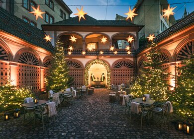 Festlich beleuchteter Innenhof mit Weihnachtsbäumen und Sternendekoration | © Christian Meixner