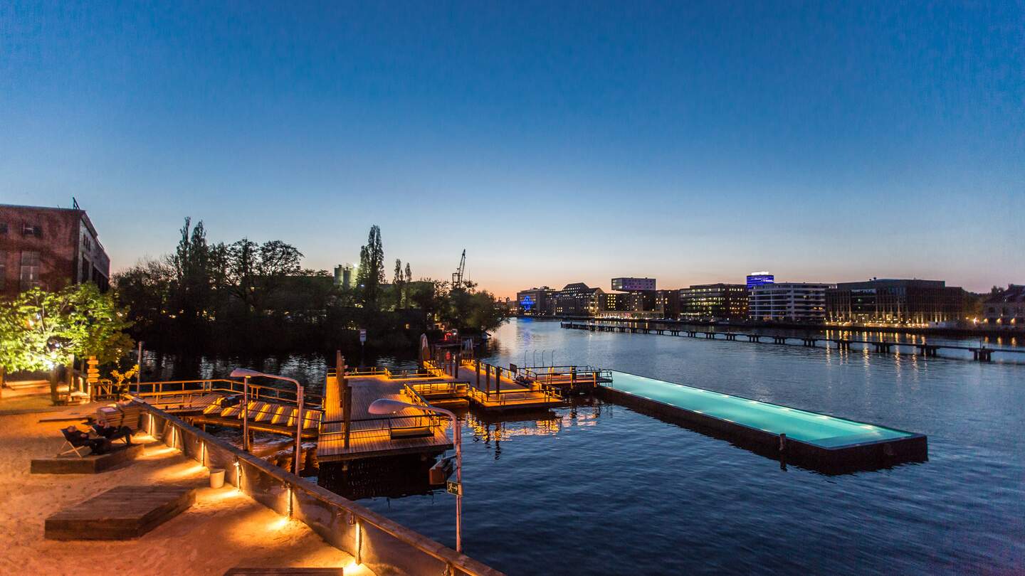 Sonnenuntergang am Badeschiff Berlin mit schwimmendem Pool auf der Spree, Blick auf Berliner Skyline und Oberbaumbrücke | © Badeschiff/Markus Nass