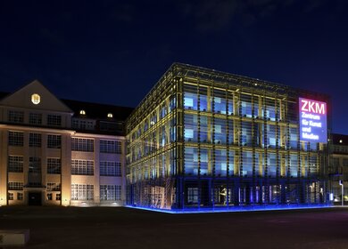 Außenansicht des Museums ZKM bei Nacht mit leuchtender Schrift | © KTG Karlsruhe Tourismus GmbH, Fabian von Poser
