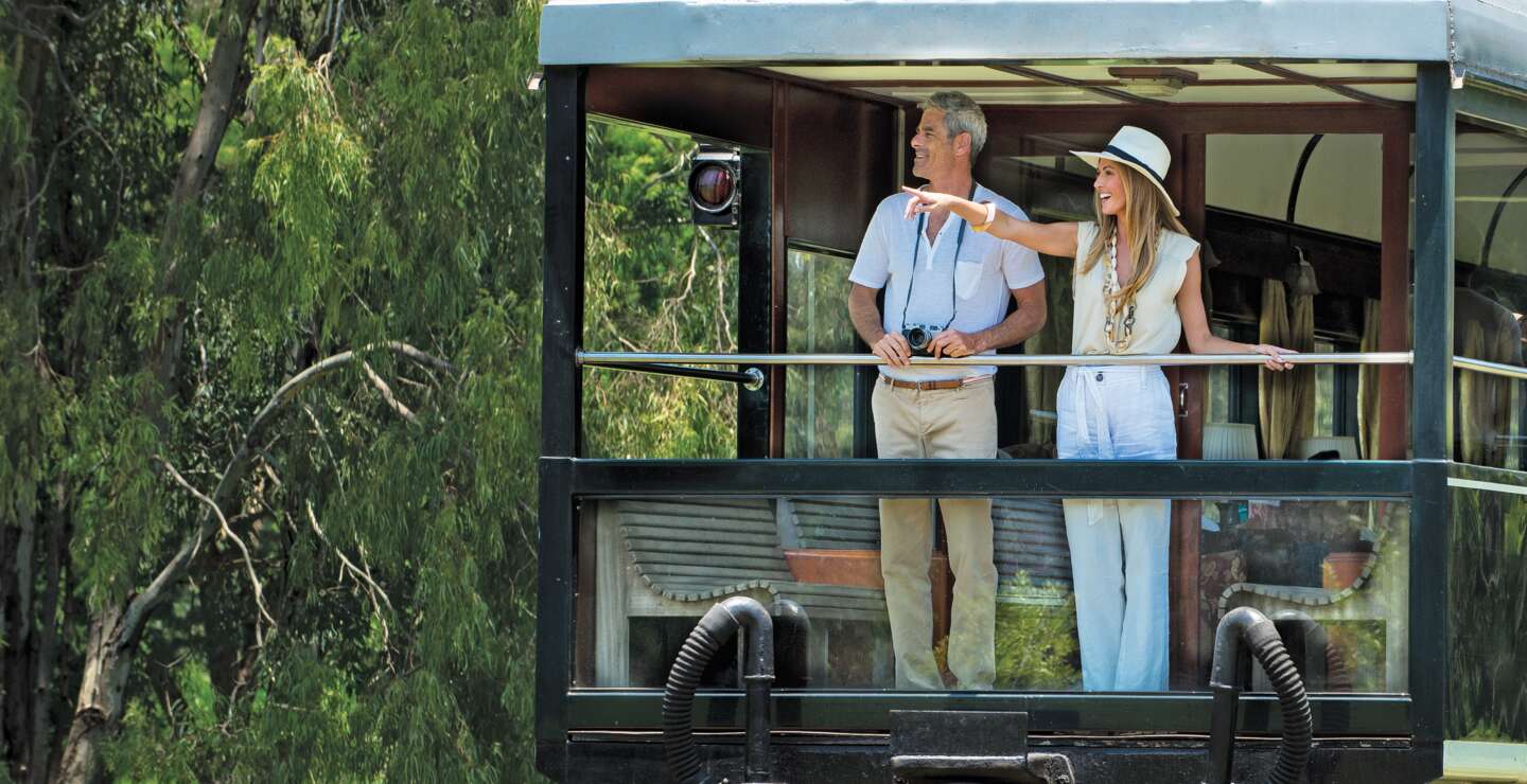 Ein schoenes Paar geniesst die Natur vom Balkon des Rovos Rail  | © DOOKPHOTO