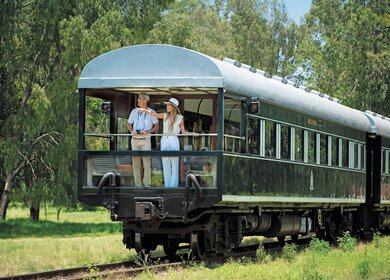 Ein schoenes Paar geniesst die Natur vom Balkon des Rovos Rail  | © DOOKPHOTO