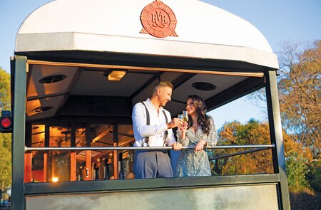 Paar steht auf dem Zug-Balkon des Luxuszuges Rovos Rail | © Rovos Rail Tours
