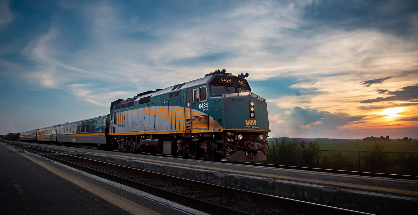 Es wird eine Außenansicht des Canadians gezeigt, welcher während des Sonnenuntergangs fährt | © VIA Rail Canada