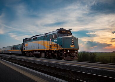 Es wird eine Außenansicht des Canadians gezeigt, welcher während des Sonnenuntergangs fährt | © VIA Rail Canada