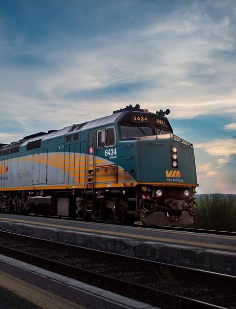 Es wird eine Außenansicht des Canadians gezeigt, welcher während des Sonnenuntergangs fährt | © VIA Rail Canada