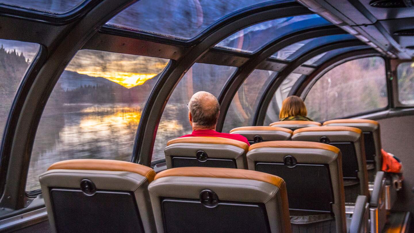 Personen sitzen in dem Panoramawagen des Canadian und schauen auf die vorbeiziehende Landschaft | © VIA Rail Canada/ALEXANDRE SOCCI