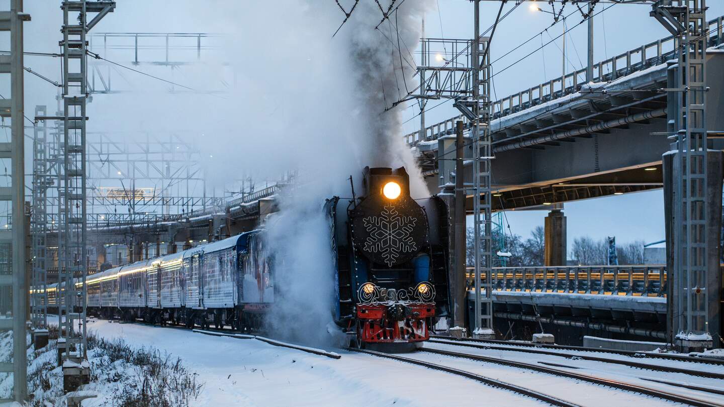 Der Weihnachtsexpress dampft im Winter über verschneite Gleise in Finnland | © GettyImages.com/Dima Berlin
