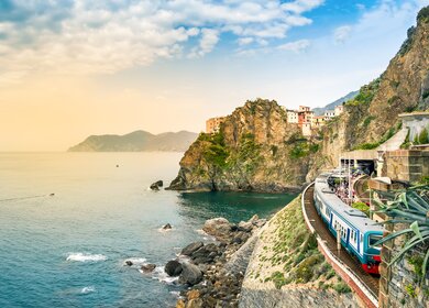Manarola, Cinque Terre, Italien - Bahnhof in einem kleinen Dorf mit bunten Haeusern auf Klippe mit Blick auf das Meer. | © GettyImages.com/	Julia Lavrinenko