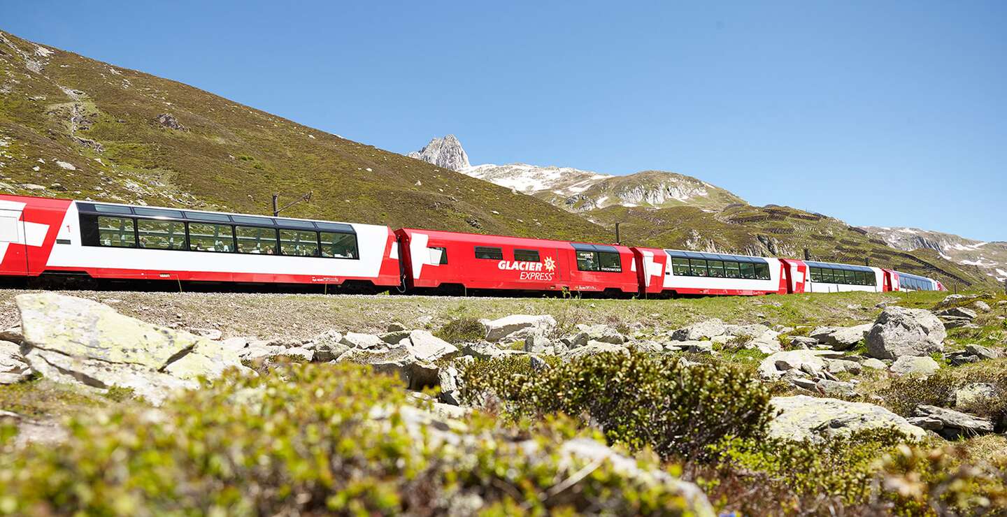 Der Glacier Express faehrt ueber den Oberalppass in den Schweizer Alpen im Fruehling | © Glacier Express AG/Stefan Schlumpf