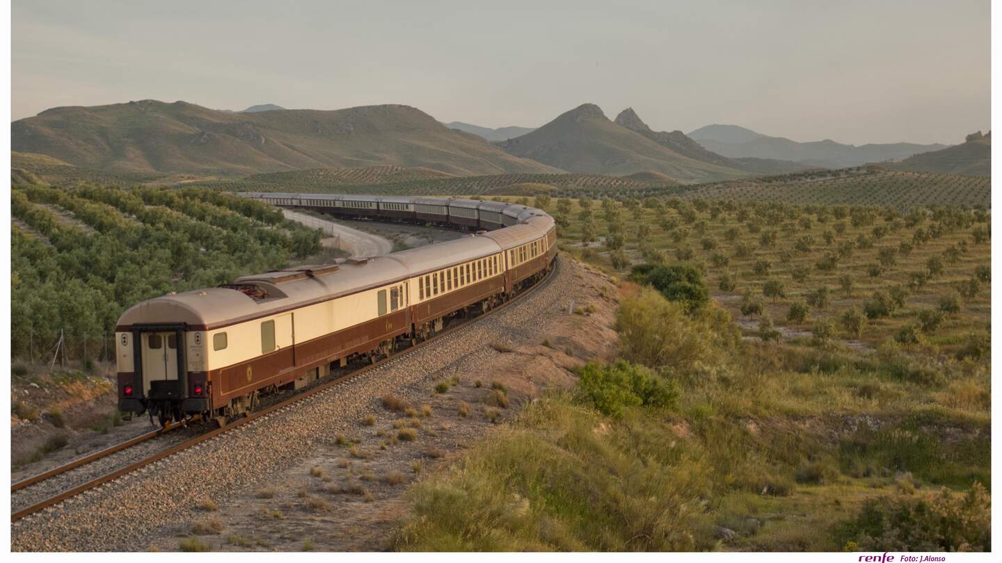 Der El Tren al Andalus auf den Schienen in einer grünen Steppenlandschaft in Andalusien. | ©  1999 Adobe Systems Incoporated/Renfe