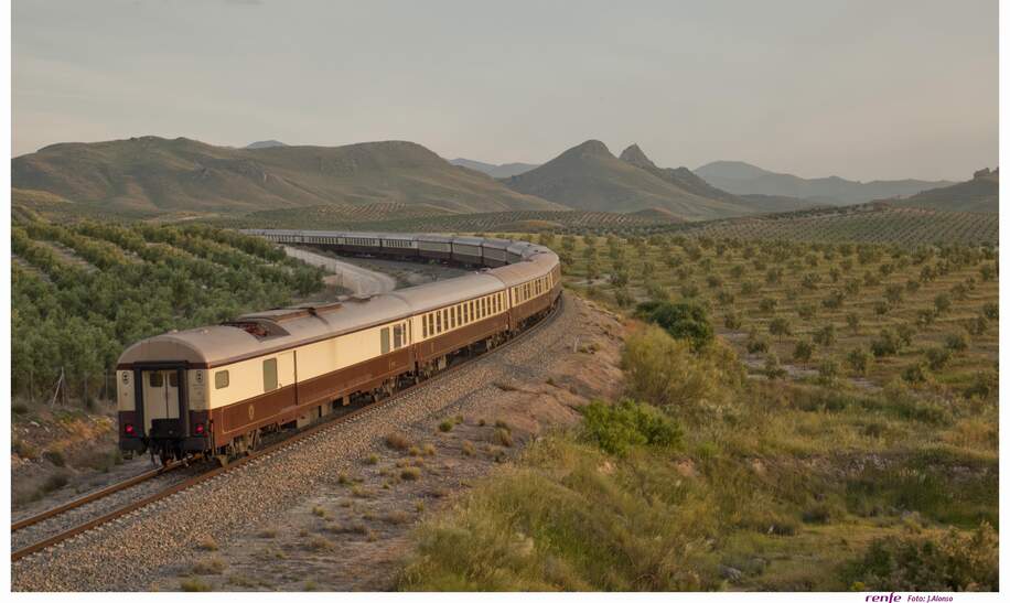 Der El Tren al Andalus auf den Schienen in einer grünen Steppenlandschaft in Andalusien. | ©  1999 Adobe Systems Incoporated/Renfe