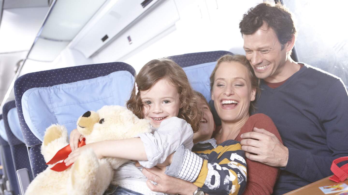 Laechelnde vierkoepfige Familie im Zug, die die Fahrt geniessen | ©  Deutsche Bahn AG