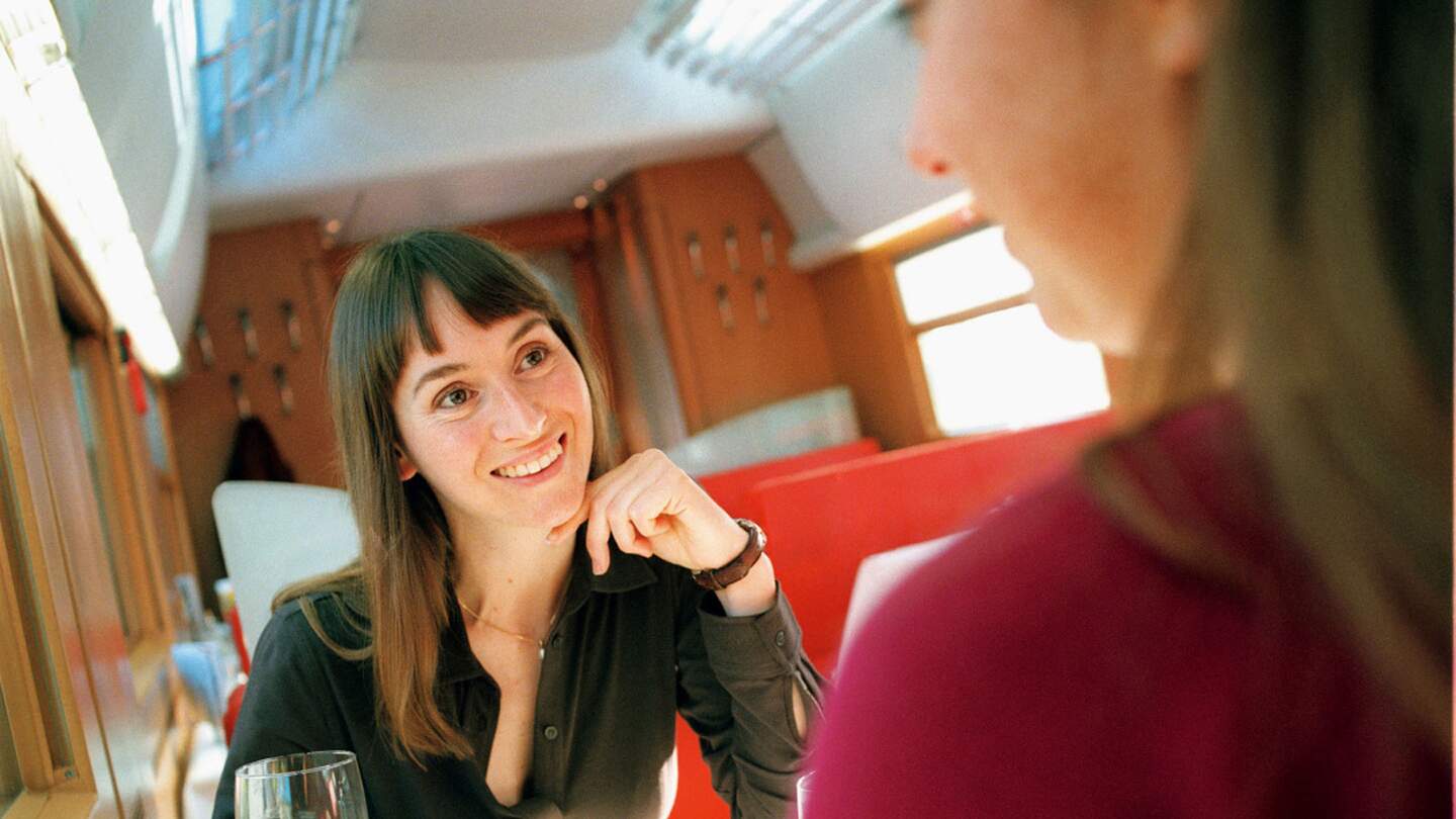 zwei Frauen in einem Speisewagen eines Zuges und genießen eine Mahlzeit | © Deutsche Bahn AG