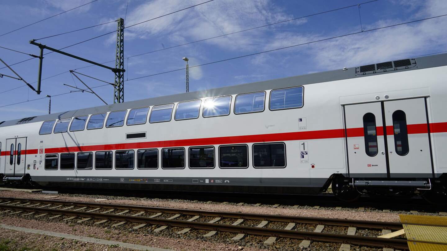 modernen, weiß-roten Doppelstock-Personenzug, der auf Gleisen unter einem klaren blauen Himmel steht. | © Deutsche Bahn AG