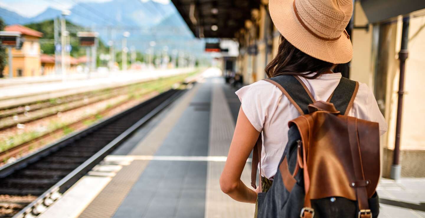 frau mit rucksack am bahngleis im sommer | © Gettyimages.com/MStudioImages
